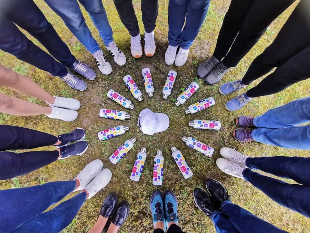 Az onboarding �dv�zl�csomag elemei: irodaszerek, iv�palack �s haszn�lati t�rgyak egys�ges c�ges megjelen�ssel.